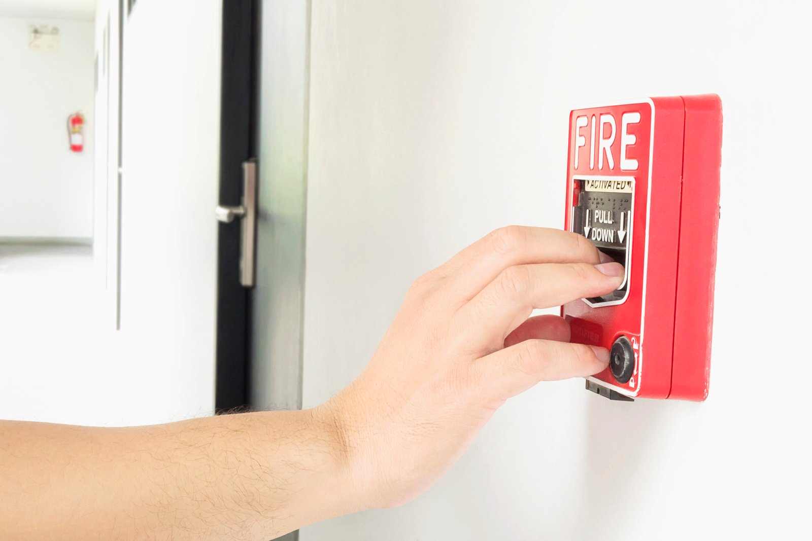 man is reaching his hand push fire alarm hand station scaled